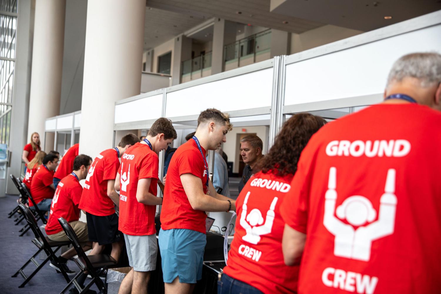 FlightSimExpo Ground Crew volunteers hand out badges and T-Shirts at FlightSimExpo 2025 registration.